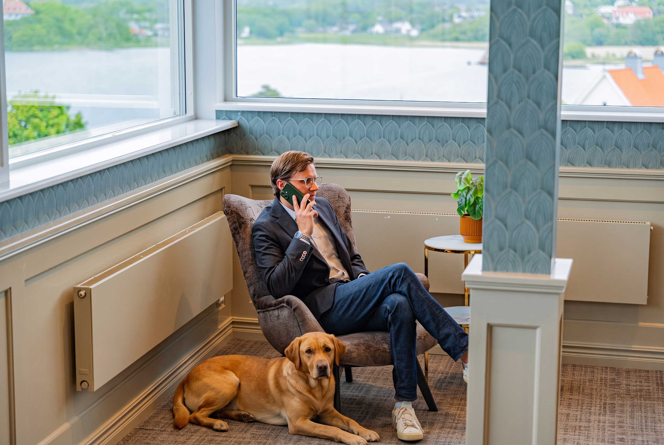 Hund som ligger vid fotöljen i konferensrummet med havsutsikt på Säröhus